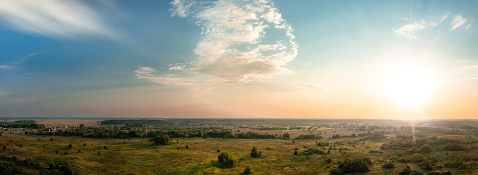 Sunset over rural landscape with fields and forest aerial panoramic view
