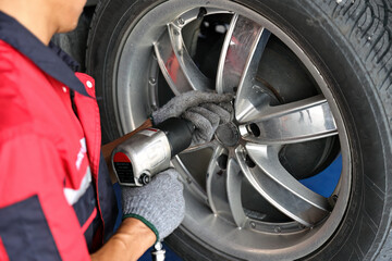 Hands of mechanic changing a wheel of a modern car