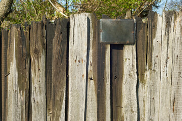 Texture of the old wooden fence with metal board for text.