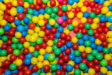 Fototapeta na wymiar Many colour plastic balls from children's small town. Background texture of multi-colored plastic balls. Colorful plastic gum balls in kid playroom or playground for children's holiday party concept