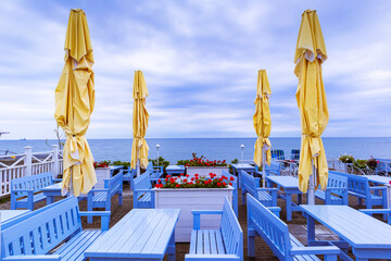 Empty beach cafe without visitors. Embankment on a cloudy day.