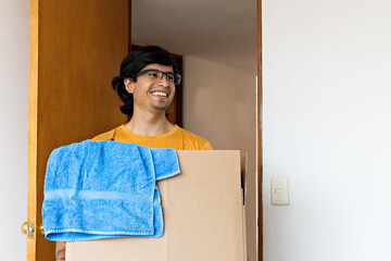 young man with a moving box entering a bedroom
