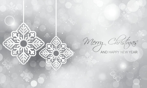 Hanging white snowflakes as decoration on Christmas and New Year bokeh shining silver background.