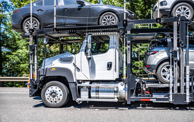 Profile of special equipped day cab car hauler big rig semi truck with cars on the two level...