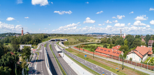 New city highway Trasa Łagiewnicka in Krakow, Poland, with tunnels for cars and tramway. The road runs between two churches. Sanctuaries of Pope John Paul II on the left and Divine Mercy on the right