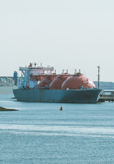 LNG Carrier in the European port during cargo operations.. LNG vessel next to the terminal. LNG ship and a container ship in the background. © I am from Mykolayiv