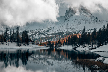 morning by the lake in the late autumn snow covered mountains in italian alps