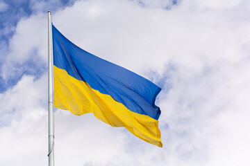 State yellow and blue flag of Ukraine on the background of the sky with clouds