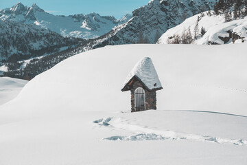 little chapel covered with snow in the mountains