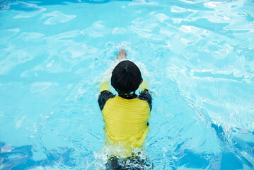 Little asian boy swim in swimming pool