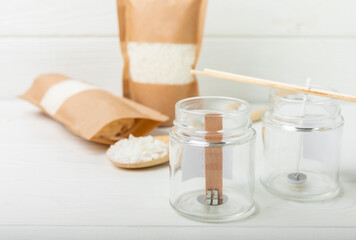 Making homemade candles.Glass jars with wicks, soy wax and fragrances on a white background.Hobby.Decor element. place for text. Place to copy.