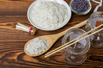 Making homemade candles.Glass jars with wicks, soy wax, dried lavender flowers and fragrances on a brown background.Hobby.Decor element. place for text. Place to copy.