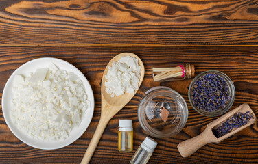 Making homemade candles.Glass jars with wicks, soy wax, dried lavender flowers and fragrances on a brown background.Hobby.Decor element. place for text. Place to copy.