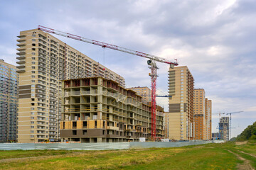 construction cranes in the construction of multi-storey, apartment buildings. Construction site. Construction of a residential area.