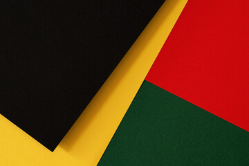 Abstract geometric black, red, yellow, green color paper background. Black History Month color...