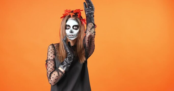 makeup for halloween skull Santa Muerte, body art. The girl is melting her hands to the camera.