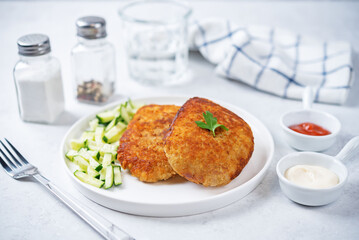 Fresh prepared schnitzel in a plate with fresh cucumber slices