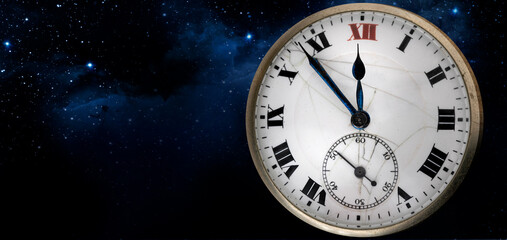 An old antique clock with roman numerals on the dial and closkwork isolated on starry sky background