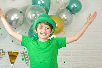 happy schoolboy on st. patrick's day. wearing a green hat