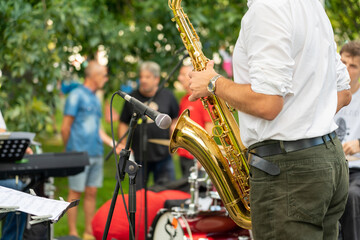 Saxophonist man in the process of playing the saxophone during a performance at a street festival