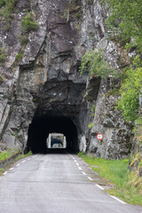Kyrping, Norway - June 9, 2022: the old Akra Fjord road, POV from a Tesla Model 3 driving on the scenic route. Tunnel and bridges in a cloudy spring day. Selective focus - obrazy, fototapety, plakaty