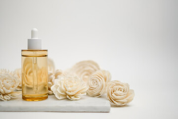 Luxury facial care serum with with white flower on white marble on white background . Beauty...