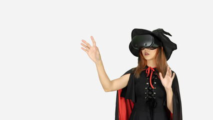 Amazed young woman touching the air during the VR experience. Horizontal studio shot. Halloween concept