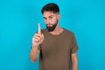 Fototapeta premium young bearded hispanic man wearing casual clothes over blue background frustrated and pointing to the front