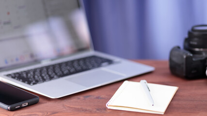 Vlogger workplace. Laptop, smartphone, notebook and camera on a wooden table. Freelancing and video...