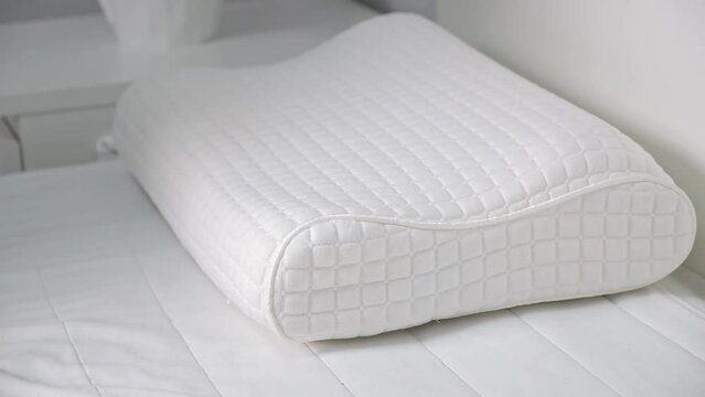 The man sleeps on a special orthopedic anatomical pillow for a flat back and healthy sleep.