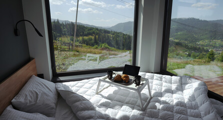 Breakfast table on white bed with mountain view
