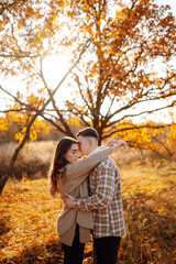 Young couple in love walking in the park on a autumn day. Enjoying time together.