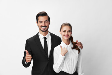 Man and woman smile with teeth business in business attire looking into camera on white insulated background hands big up. Stylish business concept paired between employees startup copy place