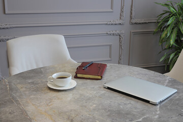 Fototapeta premium Cup of coffee, diary and laptop on the table