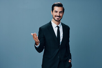 Man confident businessman standing with his hands up and a smile with teeth in a stylish suit with jacket and white shirt on a gray background portrait. The concept of young businesses and startups