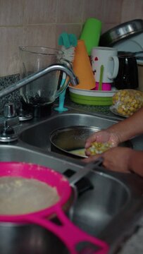 woman squeezing nance in a pan, close-up