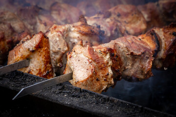 Meat shashlik, also known as shish kebab, is grilled on a charcoal grill. Slices of meat on steel skewers close-up. Delicious traditional Caucasian meat dish