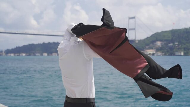 Businessman wearing his jacket.
Businessman wearing his jacket against bridge traffic at sea caner in the city. Free and happy.

