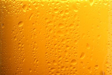 Glass of tasty cold beer with condensation drops as background, closeup