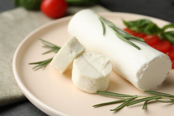 Delicious goat cheese with rosemary on plate, closeup