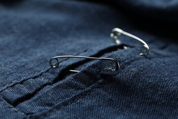 Closeup view of metal safety pins on clothing