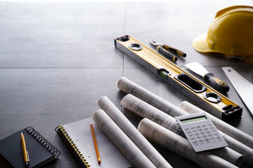 Contractor theme. Plans,  notebook and tool kit of the contractor: yellow hardhat, libella, saw and...
