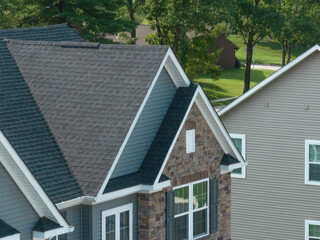 Close up view of double gable roof with stone and vinyl covering