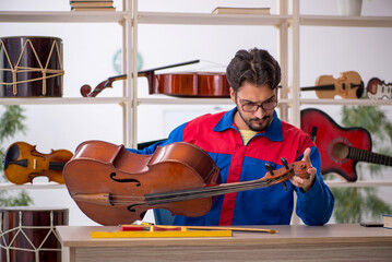 Young man repairing musical instruments at workshop