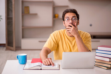 Young male student preparing for exams at home