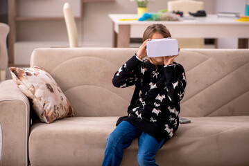 Obraz premium Young little girl enjoying virtual glasses at home
