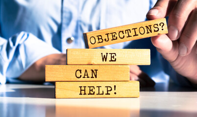 Wooden blocks with words 'Objections? We Can Help!'. - obrazy, fototapety, plakaty