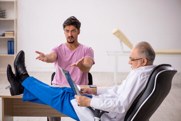 Obraz premium Young male patient visiting old male doctor radiologist