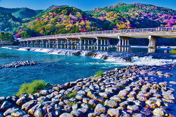 Fototapeta na wymiar 京都嵐山渡月橋の秋は紅葉に包まれます 