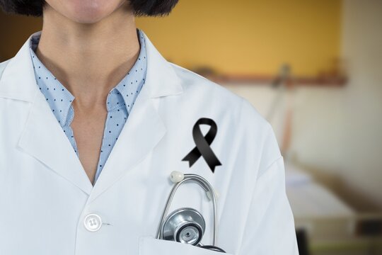 Mid section of lady doctor with black ribbon standing on robe standing in the hospital
